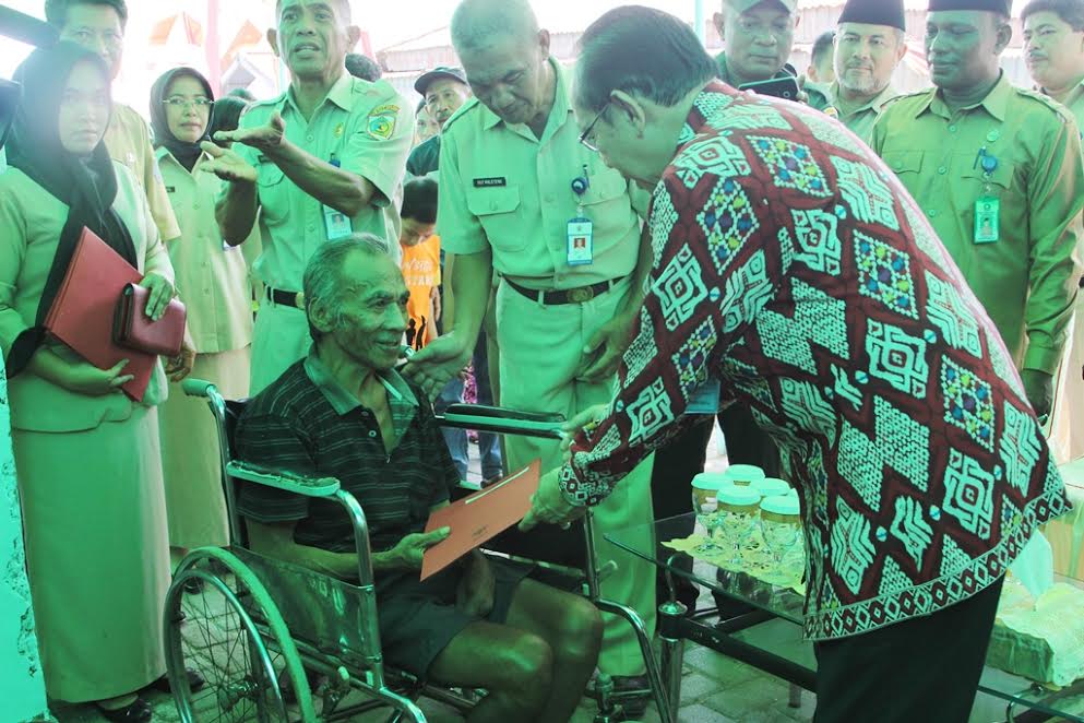 Kepala BKKBN Pusat menyerahkan bingkisan kepada salagh satu warga di Kampung KB Kotamobagu