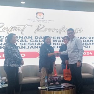 Saat Komisioner KPU Manado Hasrul Anom memberikan bingkisan kepada Pemateri Rakor pada Jumat (26/7/2024)